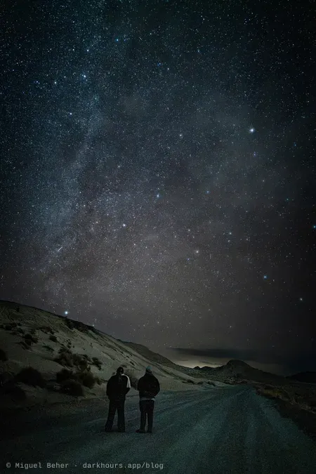 Two stargazers on a dirt road under the winter Milky Way, Knolls Recreation Area, Utah