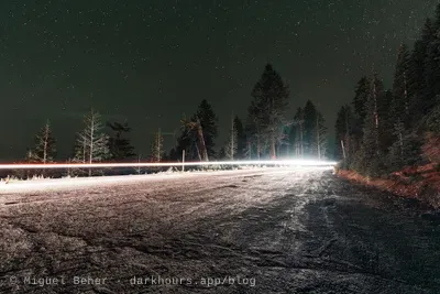 Red and white car light trails on the Mt Ashland road under a starry sky