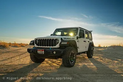 White Jeep Wrangler Rubicon backlit by the setting sun at Knolls Recreation Area, Utah